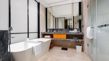 A modern bathroom with a freestanding bathtub, a large mirror, and a glass shower enclosure.