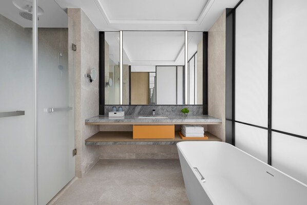 Un baño moderno con un espejo grande, una bañera y un mueble tocador con lavamanos y perchero.