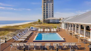 A pool area with lounge chairs, a swimming pool, and a view of the beach and ocean. - 2bd 2.5 bath with beach club, pools, hot tub, golf (Pensacola)