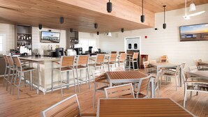 A modern restaurant with wooden ceiling, bar area, and seating arrangement. - 2bd 2.5 bath with beach club, pools, hot tub, golf (Pensacola)
