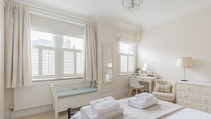 A bedroom with a bed, a desk, a chair, and a window with curtains. - I Came To Boogie (London)