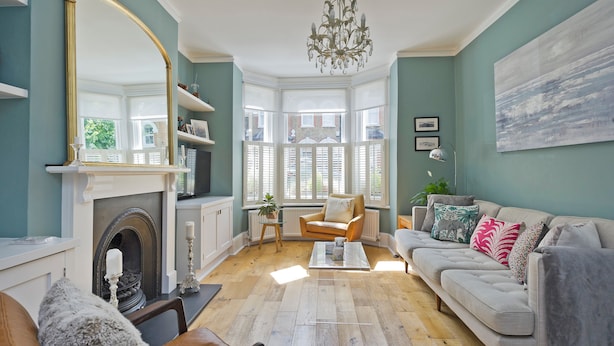 A living room with a fireplace, a sofa, a coffee table, and a large mirror. - I Came To Boogie (London)