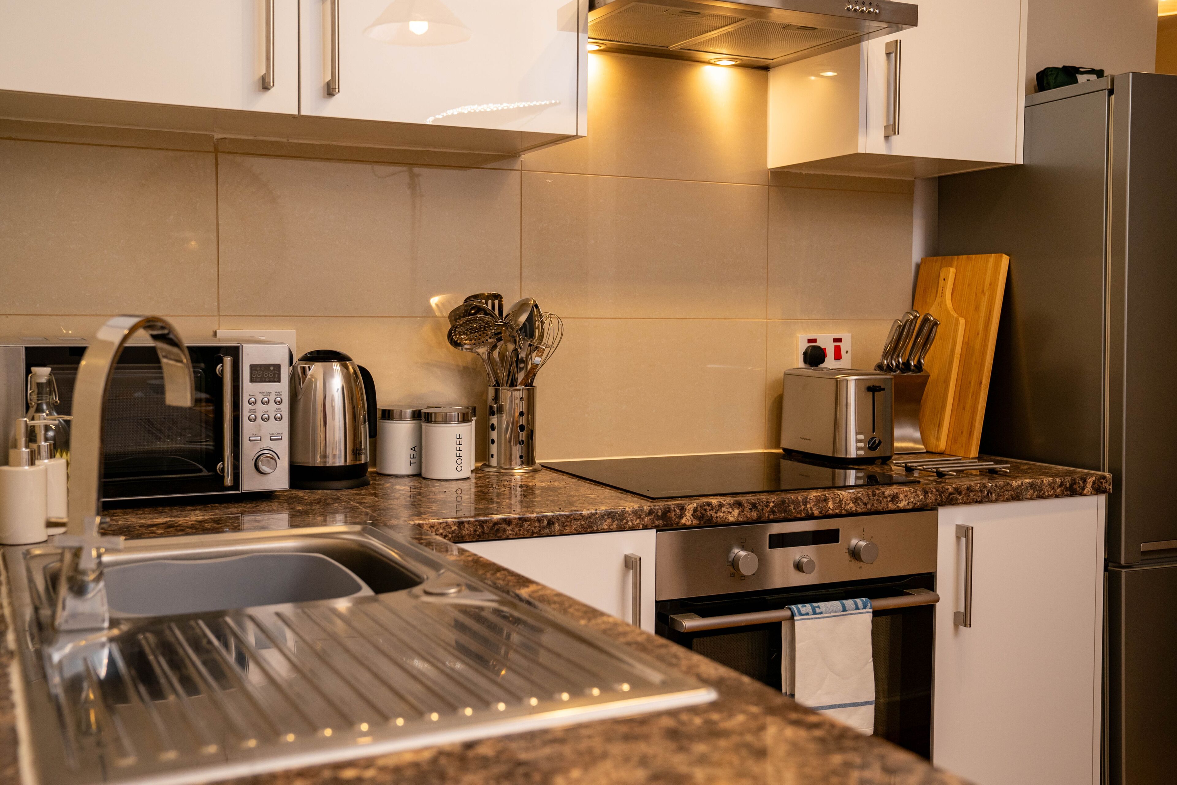A modern kitchen with stainless steel appliances, a granite countertop, and a built-in oven.