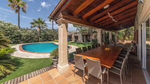 A covered patio with a pool, outdoor seating, and lush landscaping. - Villa Marjals - Eight Bedroom Villa, Sleeps 16 (Muro)
