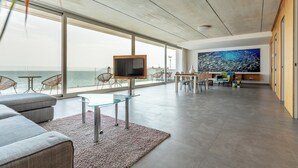 Un vaste espace de vie doté d’une grande télévision, de sièges confortables et offrant une vue sur la mer.