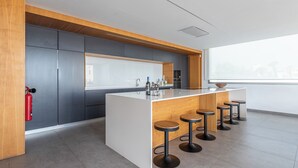 Une cuisine moderne dotée d’un îlot central, de tabourets de bar et d’un extincteur.