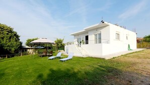 A modern white house with a covered patio, a small pool, and two lounge chairs. - Emerald Private Villa in Kalavarda Rhodes (Rhodes)