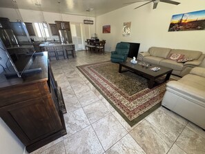 Amplia sala de estar con cocina, mesa de comedor y sofá.