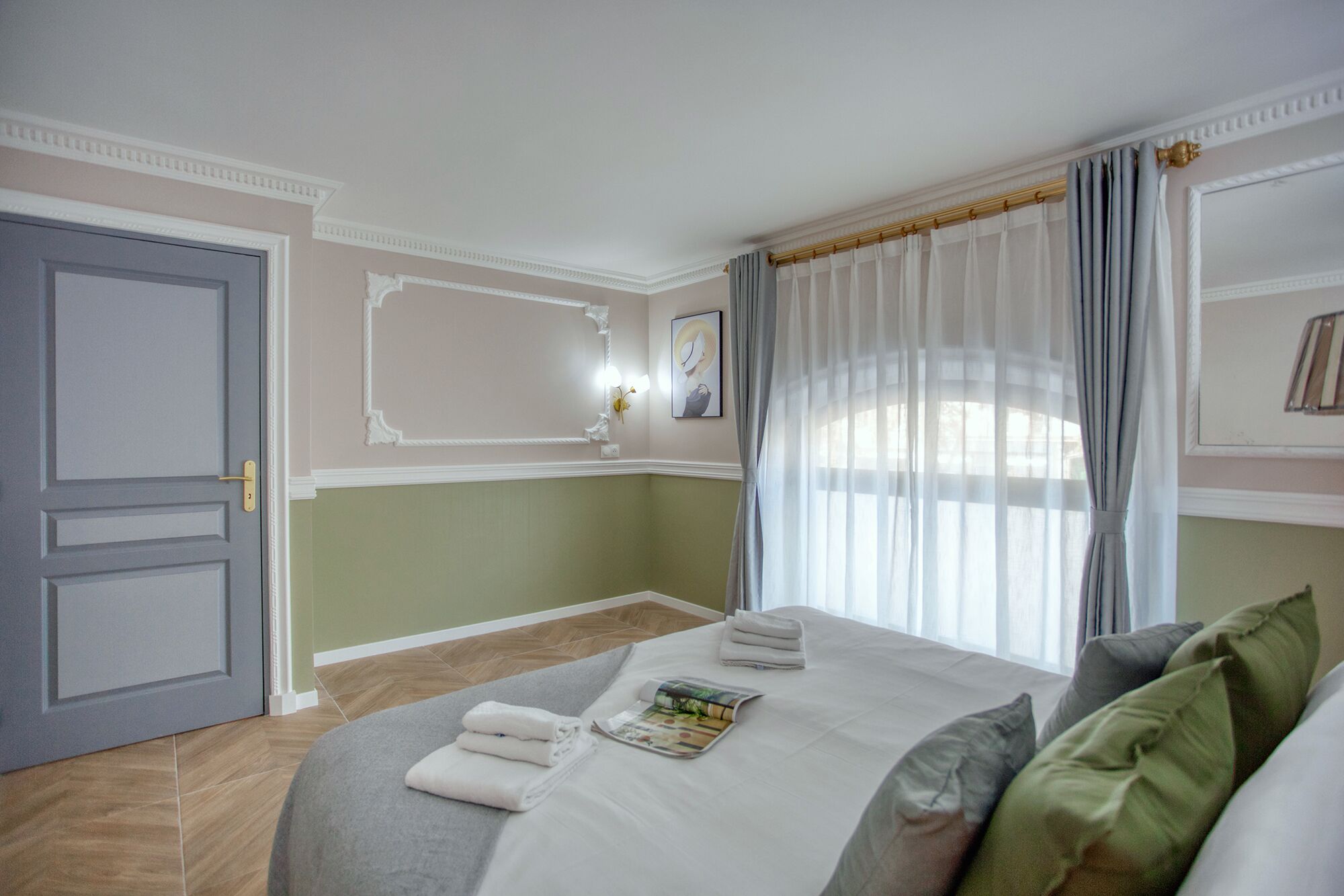 Una habitación de hotel con una cama, una puerta y una ventana con cortinas.