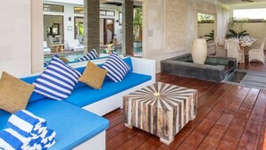 Ein modernes Wohnzimmer mit einem blauen Sofa, gestreiften Kissen und einem Holztisch.