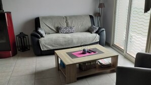 Un soggiorno con divano, tavolino e un quadro appeso al muro.