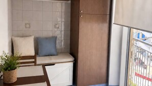 Parvekkeella on oleskelualue, puinen kaappi ja ruukussa oleva kasvi.