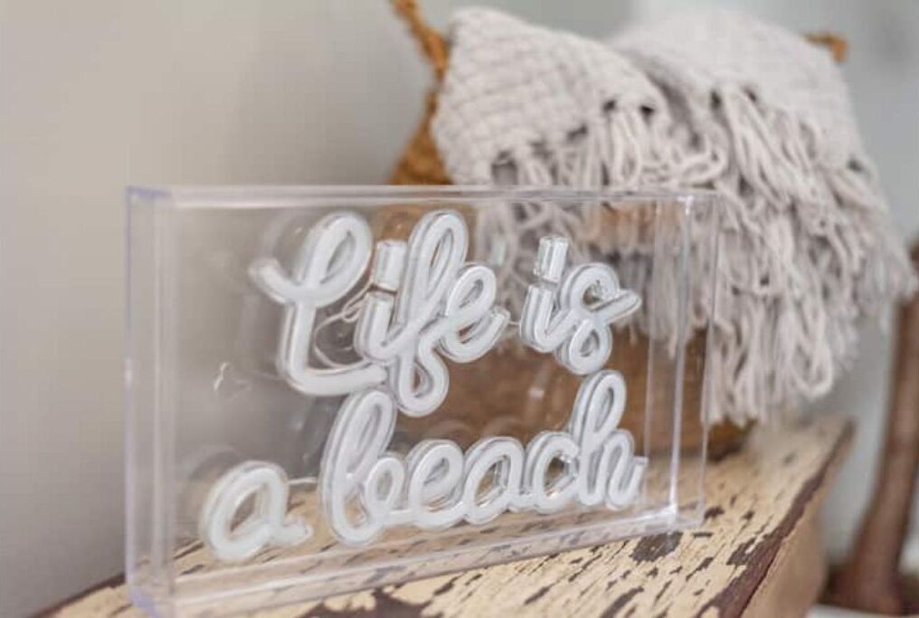 Een transparant acryl bord met de tekst 'Life is a beach' in grote letters.