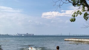 Une plage avec une chaise et une personne qui marche en direction de l’eau.