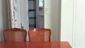 A dining area with a wooden table and wicker chairs. - Studio Lumineux Dans Quartier Calme, Avec Terrasse, 5 mn à Pied du Centre Ville (Basse-Terre)