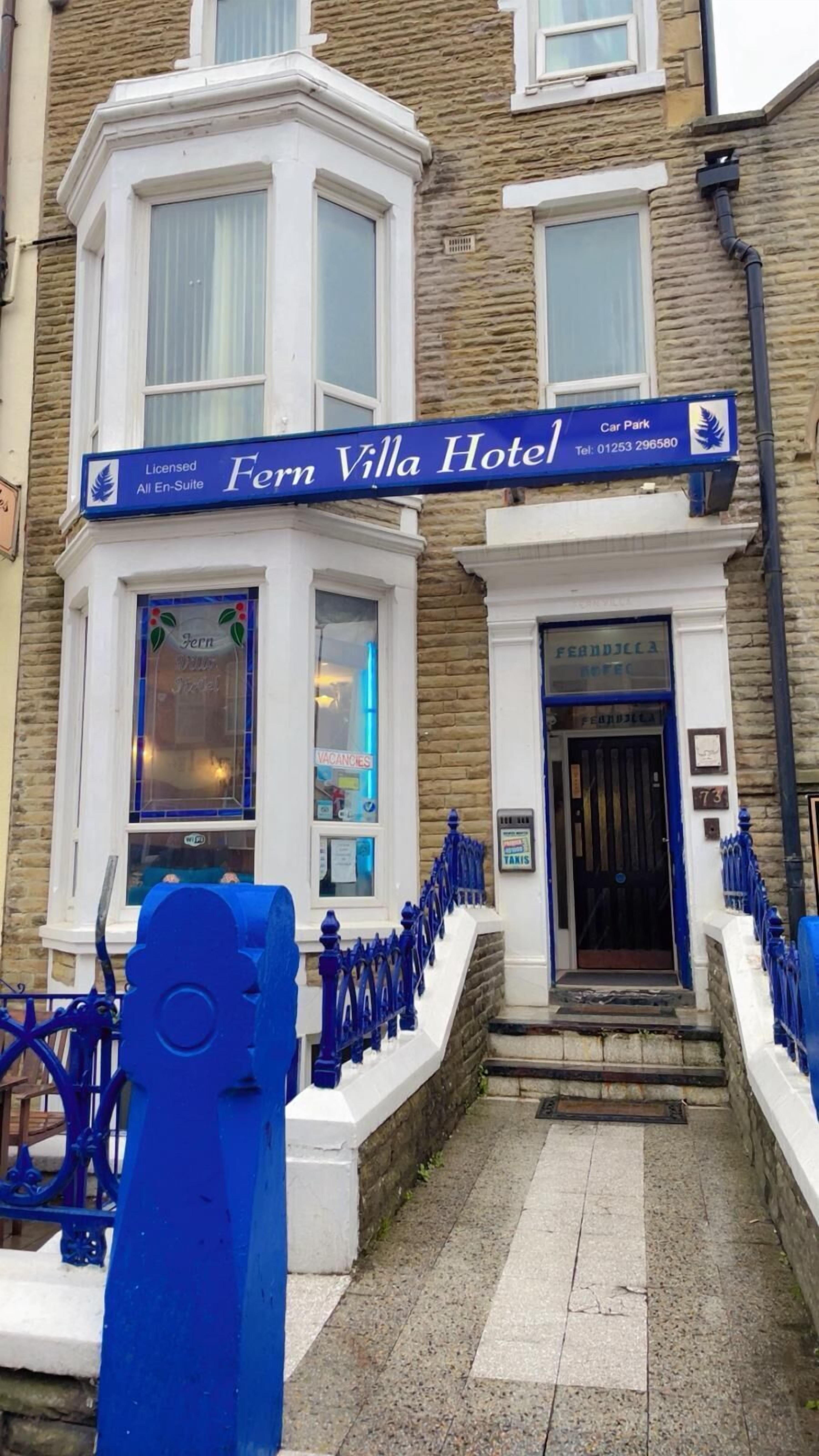 The exterior of Fern Villa Hotel, featuring a traditional stone facade, a blue entrance sign, and a small car park sign.