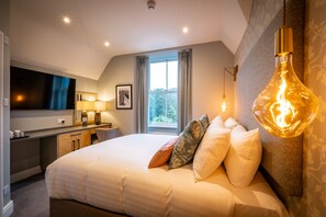 A modern hotel room with a large bed, a desk, a flat-screen TV, and a unique light fixture. - Ambleside Fell Rooms (Ambleside)