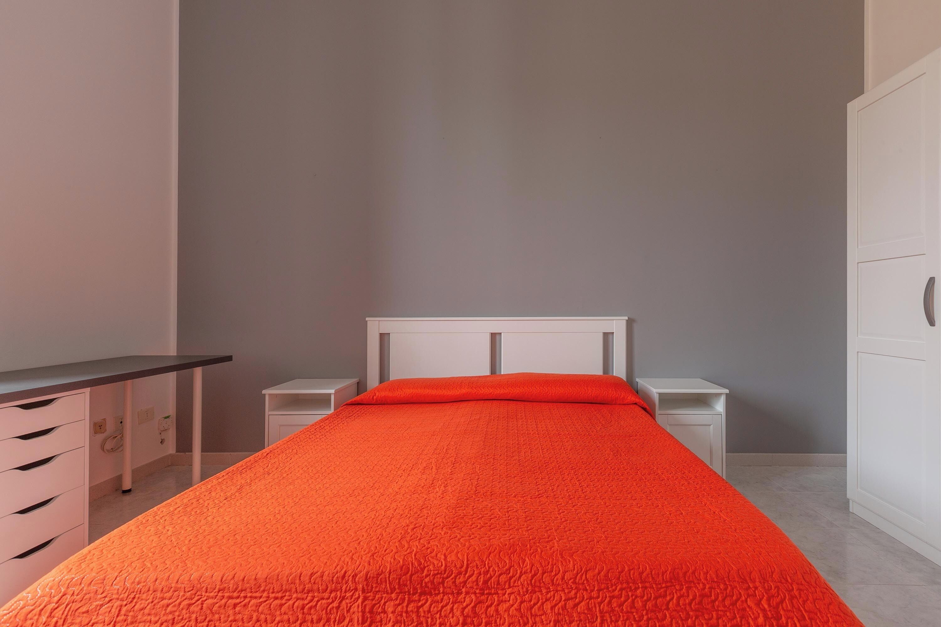Une chambre à coucher avec un lit, un bureau et une armoire.