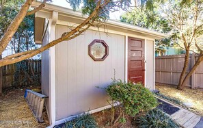 Situated in a lush garden, this charming shed offers a cozy retreat.