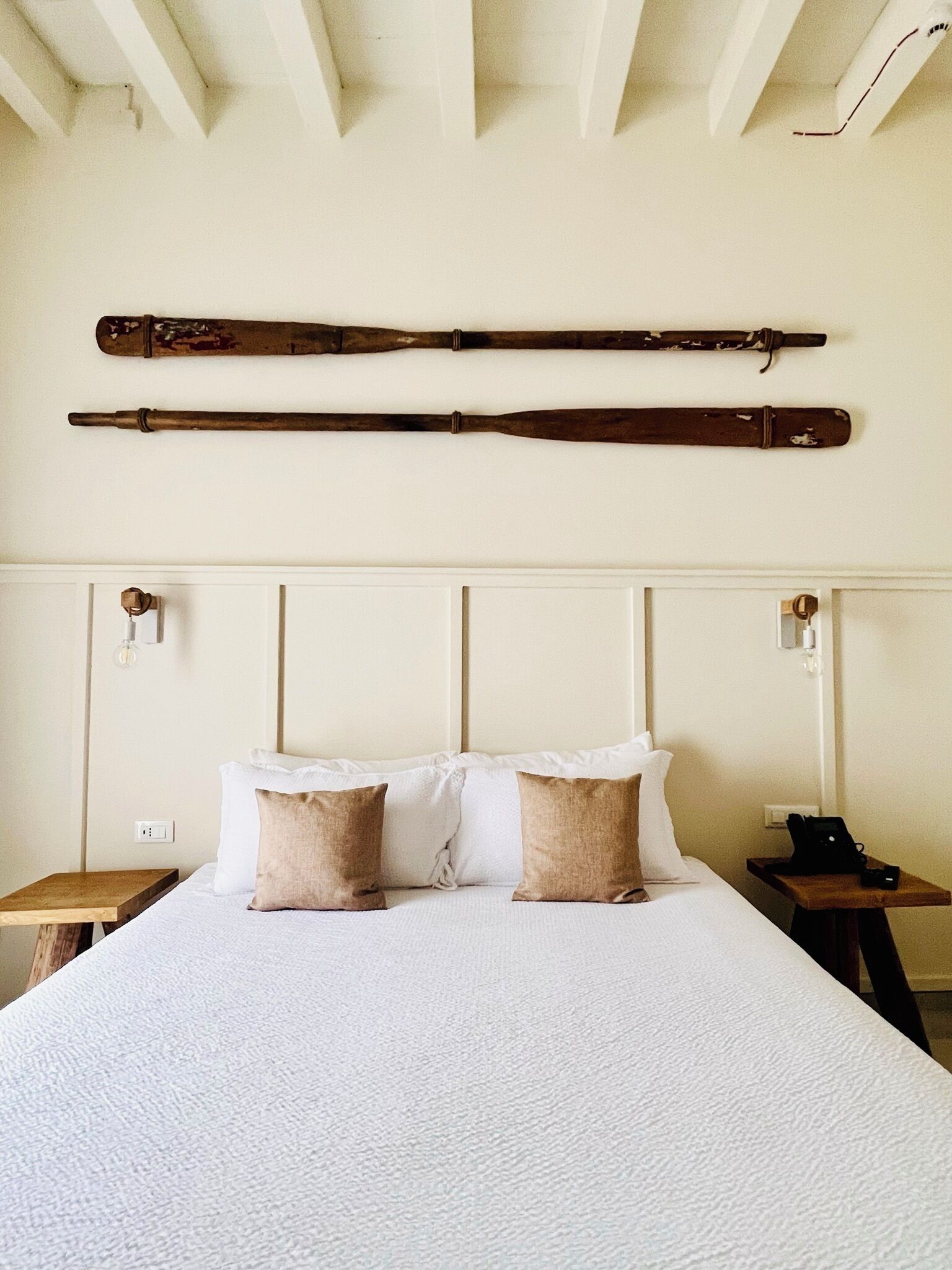 Un dormitorio con una cama grande, dos mesitas de noche y un cabecero de madera.