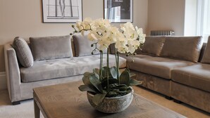 A living room with a grey sofa, a coffee table with a plant, and two framed pictures on the wall. - Church View (Scarborough)