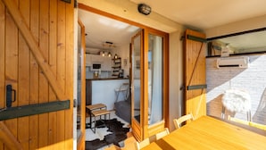 Ein gemütliches Zimmer mit Holztür, einem Esstisch und Blick auf eine Küchenzeile.