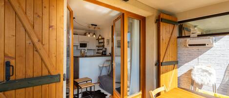 Habitació acollidora amb una porta de fusta, una taula de menjador i vista a una zona de cuina.