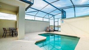 En inomhuspool med en glasvägg, en täckt uteplats och utsikt över omgivningen.