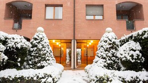A brick building with a symmetrical facade, large windows, and a central entrance. - Elegante alloggio di grandi dimensioni (110 mq) in parco privato di 6000 mq (Torino)