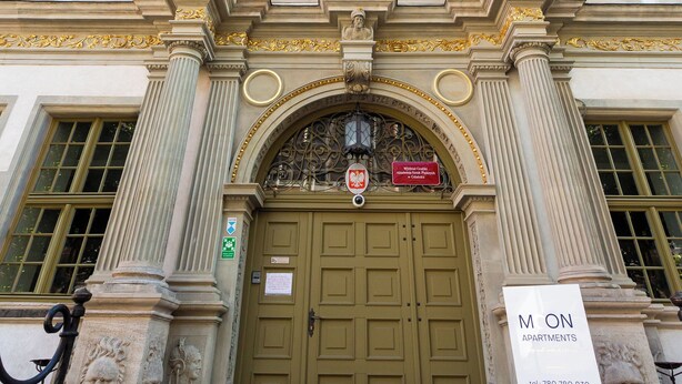 A grand building with classical architecture, featuring a large arched entrance and columns. - Moon Apartments Gdańsk (Gdansk)