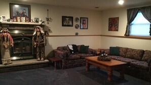 A living room with a fireplace, a sofa set, a coffee table, and a statue. - 3 Bedroom, 2 Bathroom Home - EAA Rental Only (Oshkosh)
