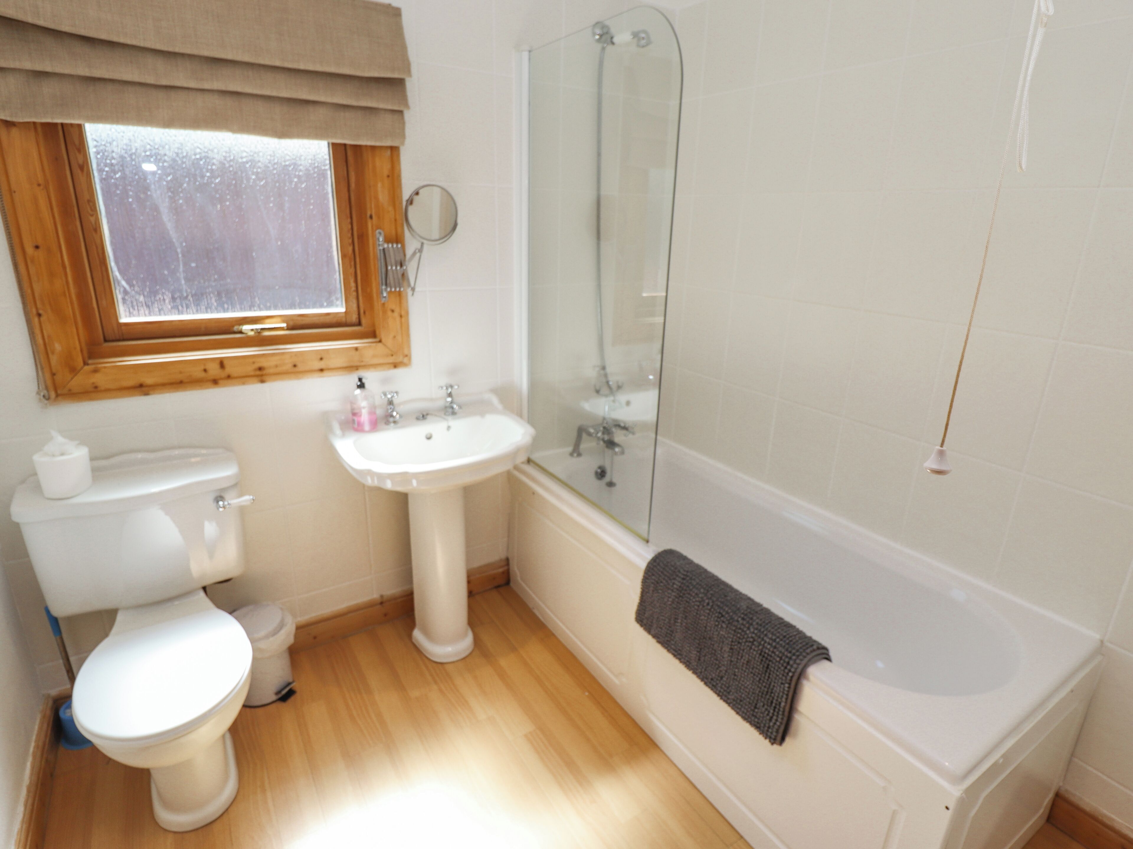 Een badkamer met toilet, wastafel en bad.