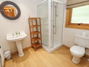A bathroom with a sink, toilet, shower, and a wooden shelf. - 64 Acorn Lodge Kenwick Park (Louth)