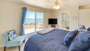 Ein Schlafzimmer mit einem großen Bett, einem Fernseher und Meerblick.