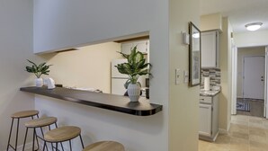 A kitchen with a bar area, stools, and potted plants. - 4 Mi to Dtwn: Pet-Friendly Abode in Tallahassee! (Tallahassee)
