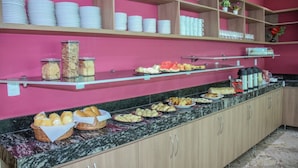 Uma mesa de buffet com diversos alimentos e utensílios.