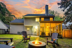 A house with a fire pit in the backyard, a covered patio, and a large window overlooking the yard. - Country Oasis w/ Game Rm, Mins from DWTN & Airport (North Charleston)