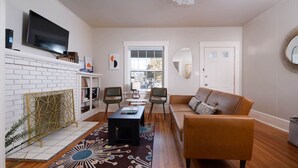 Una sala de estar con chimenea, televisor, sofá y mesa de centro.
