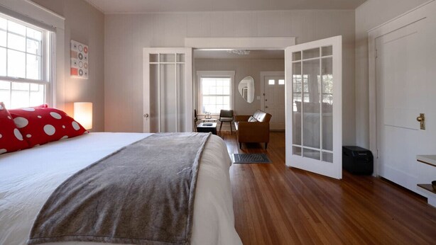 Una habitación de hotel con cama, escritorio, silla y armario.