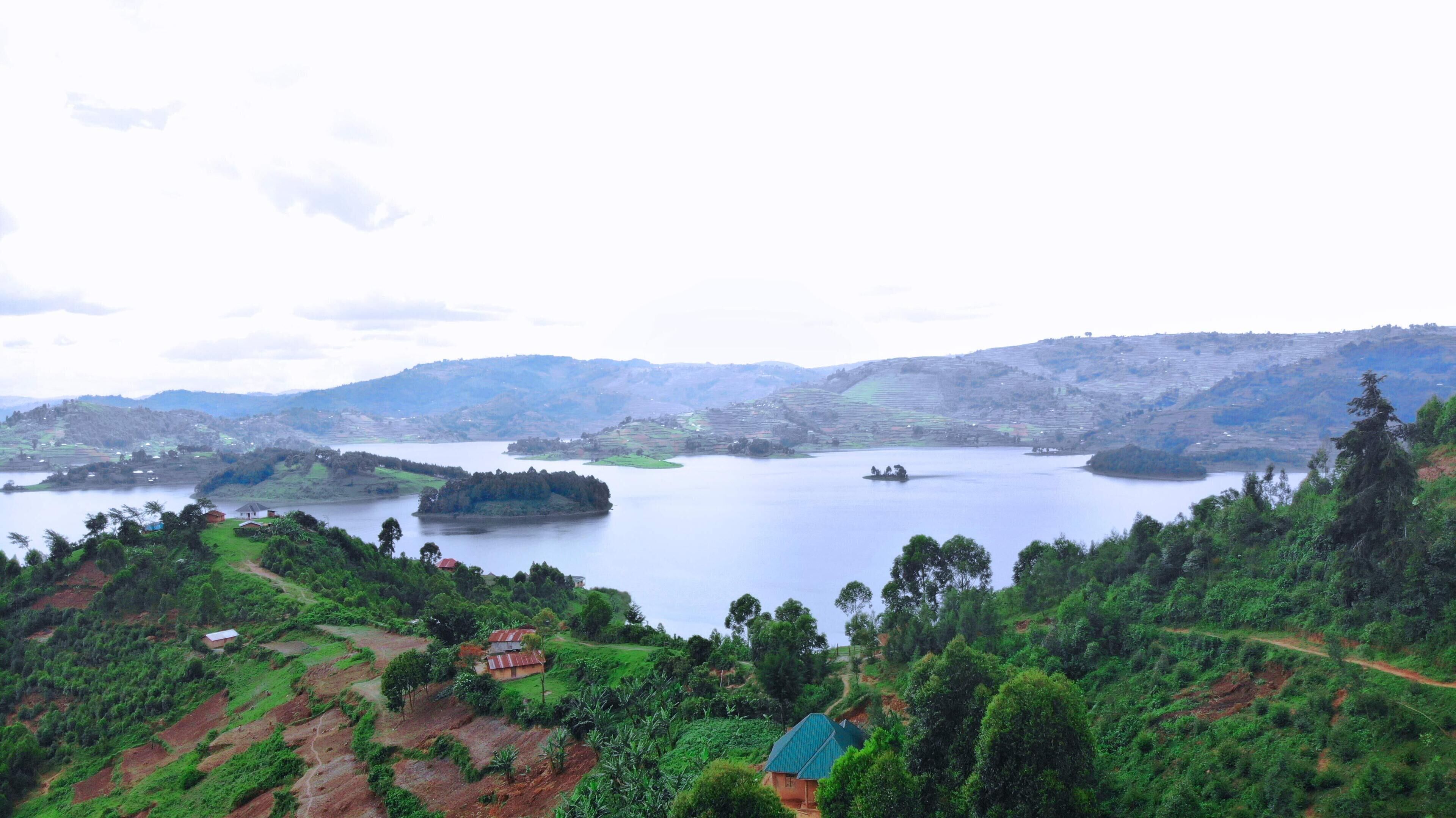 A panoramic view of a lake surrounded by lush greenery and terraced hills.