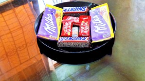 A glass table with a black tray holding various chocolate bars. - Calm apartment, close to the beach + Chocolat gift
 (Agadir)
