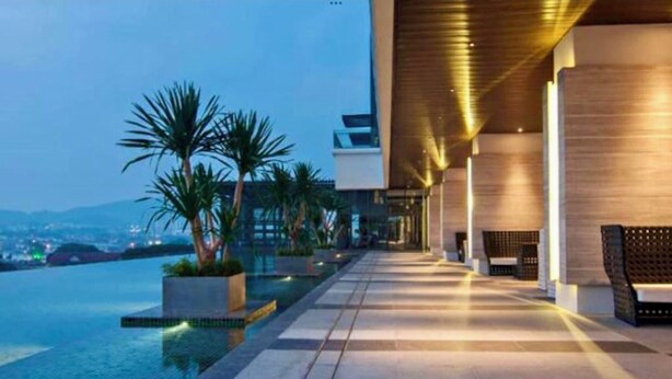 A modern hotel with a pool, outdoor seating, and a view of the cityscape. - The Elements at Jalan Ampang (Kuala Lumpur)