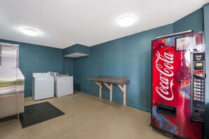 Convenient laundry facilities offer a stainless steel refrigerator, washing machines, and a table for folding.