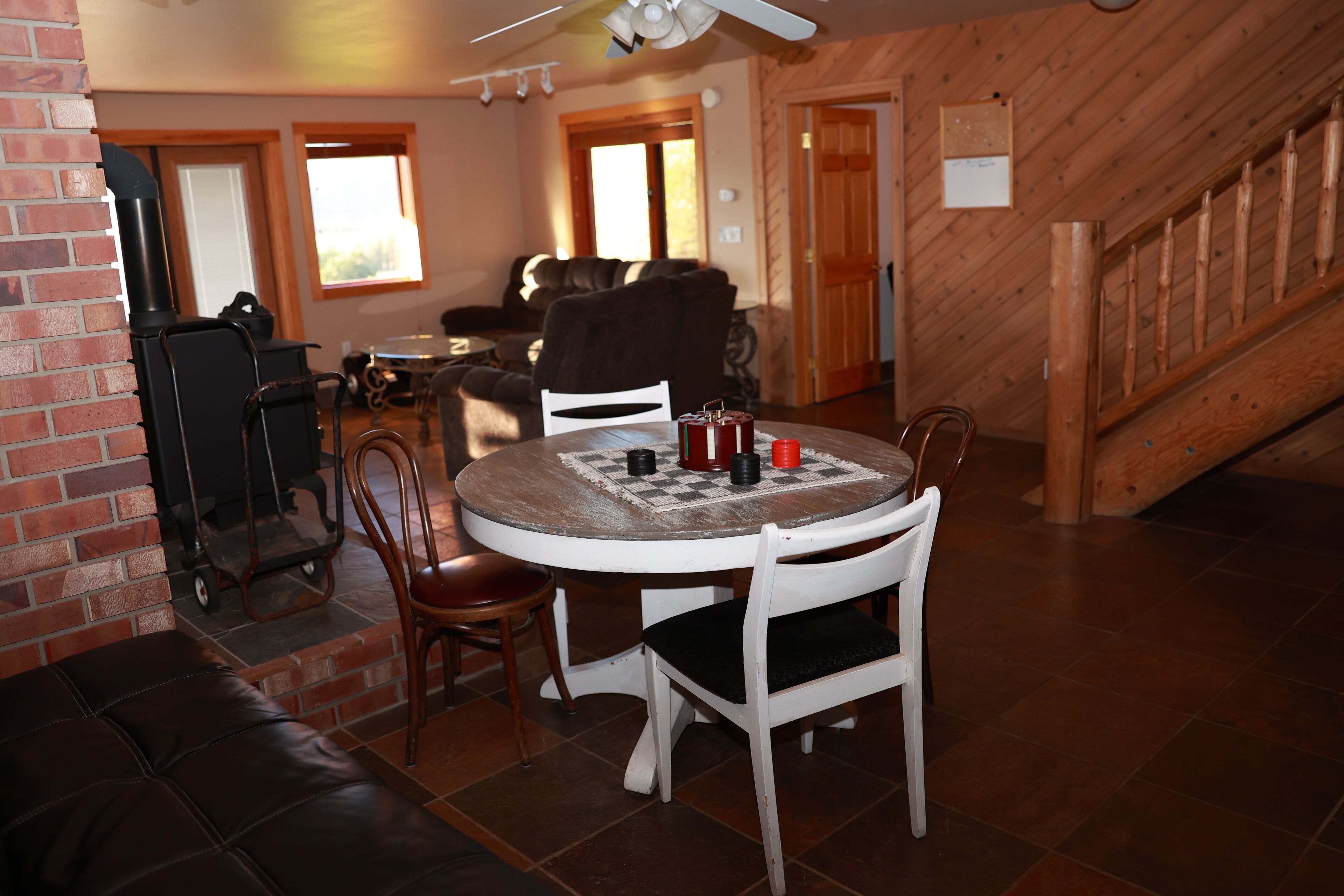 A cozy dining area with a round table, chairs, and a chessboard.