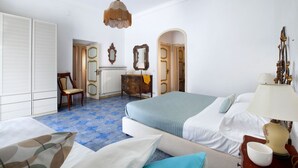 Una habitación de hotel con una cama, una silla, un tocador y una lámpara.