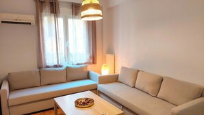 Een woonkamer met twee banken, een salontafel en een lamp.