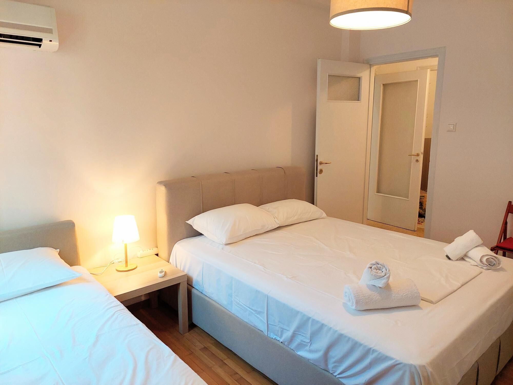 Une chambre d’hôtel équipée d’un lit, d’une table de chevet, d’une lampe et d’un appareil de climatisation.