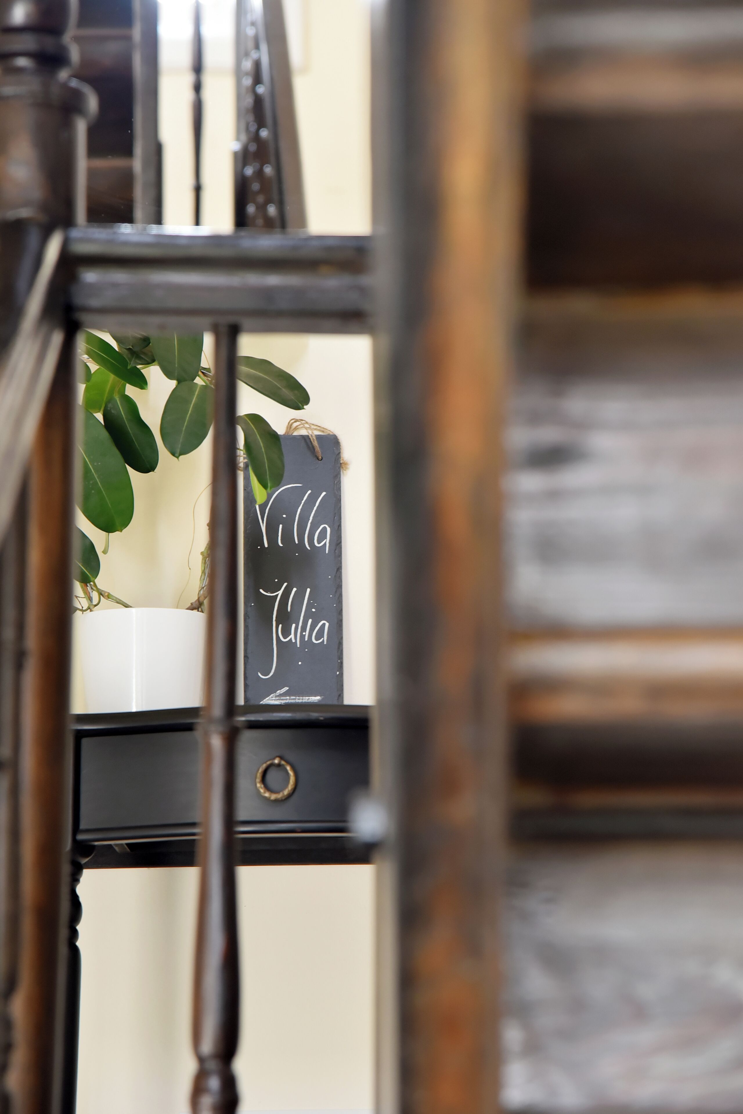 A staircase with a potted plant and a sign that reads "Villa Julia."
