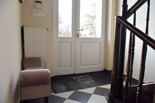 A room with a checkered floor, a radiator, a door with a handle, and a chair. - Calm escape in historical athmosphere - Villa Giulietta Budapest, free parking (Budapest)