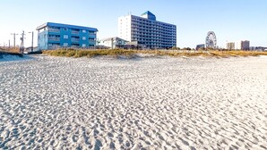 A beach with a blue building and a white building in the background. - Cozy Beach Condo Sleeps 6 POOL
 (Carolina Beach)